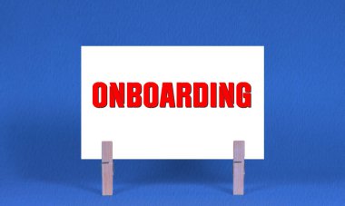 Onboard Sembolü. Sözcükler Beyaz Dikdörtgen Kağıt üzerinde ONBOARDING Tahta Çamaşır Mandalı Mavi Arkaplan. Kopyalama Alanı ile İş Sürdürme Kavramı