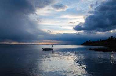 Titicaca Gölü 'nde gün batımında bir balıkçıyla