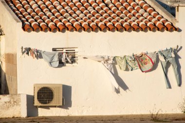 Çamaşır ipi ve çamaşır ipi olan eski beyaz bir ev. Portekiz.