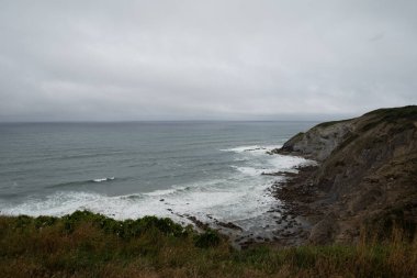 Bask ülkesinde (İspanya) Bilbao 'ya yakın sinek. Fotoğraf yağmurdan hemen sonra çekildi, rüzgarlı bir günde dalgalı deniz ile..