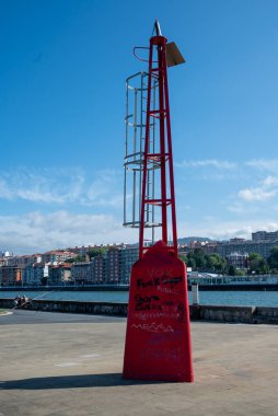 Red metal tower at the docks of Ibaizabal river mouth close to Las Arenas city beach of Bilbao. It is one of the best beaches of Getxo in Euskadi, we are at the river mouth, in a sunny day of summer. clipart