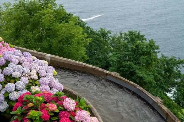 Suyun akan kanalı, renkli petunyalar ve sardunyalarla çevrili, İspanya 'nın Biscay ilindeki Bask bölgesinde San Sebastian' daki Monte igueldo eğlence parkında kullanılıyor..