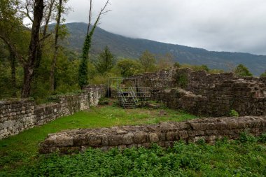 İtalya 'nın Friuli Venezia Giulia bölgesindeki Meduno antik kalesinin kalıntıları. Yenileme aşamasında. Uzun tahta bir iskele, metal bir yapı iskelesi ve tarihi bilgilerle dolu bir tabela var..