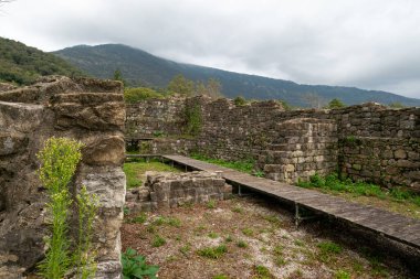 İtalya 'nın Friuli Venezia Giulia bölgesindeki Meduno antik kalesinin kalıntıları. Yenileme aşamasında. Sonbaharın sisli bir gününde, ortada uzun bir tahta kaldırım var..