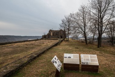 The germanic shrine of Pinzano al Tagliamento in mount Pion in a foggy morning of winter with informational signs about its history, The ossuary was built after ww1 to let the dead soldiers remains of the great war rest in peace, but still incomplete clipart