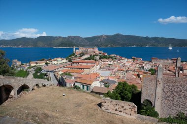 Toskana 'nın Elba Adası' ndaki Portoferraio şehrinin panoramik manzarası, ön planda kuru tarlalar bulunan kale duvarlarından Livorno 'ya kadar uzanır.