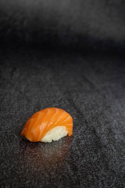Siyah arka planda somonlu nigiri