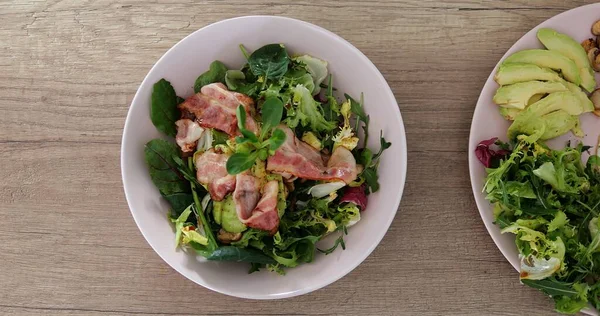 Sağlıklı dengeli besleyici ev yapımı kahvaltılık ya da öğle yemeği. Yeşillik, avokado, salata ve pastırmayla servis edilen iki tabağın parçası. Yüksek kalite fotoğraf