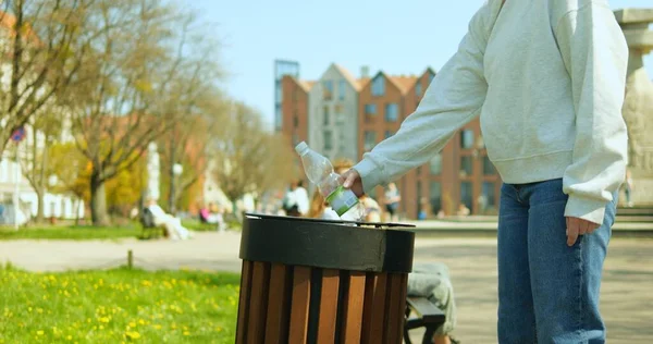Yüzü olmayan genç bir kadın sokaktaki çöp kutusuna boş plastik şişe atıyor. Saç örgülü isimsiz bir kız, şehir parkındaki bankın yanında duran çöp tenekesini kullanıyor. Şehir ortamını temiz tutma kavramı.