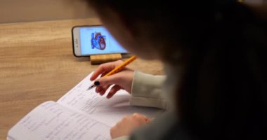 Ergen, bilgisayardan bilgisayara akıllı telefon yazma konusunda biyoloji dersi alıyor. Tanınmayan kız, eğitim süreci için modern teknolojiyi kullanıyor. Yüksek kalite 4k görüntü