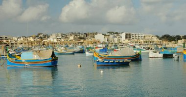 Marsaxlokk Körfezi 'nin panorama görüntüsü. Çok sayıda parlak renkli tekne var. Ünlü resimli Malta balıkçı köyü deniz bölgesi.