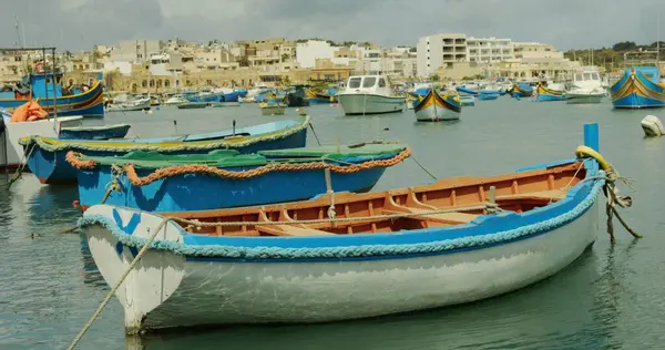 Renkli otantik tekneler yaz günü Marsaxlokk şehrinde suda yüzerler. Deniz kıyısında duran Malta balıkçı köyü. Malta 'nın ünlü ve pitoresk turistik simgesi.