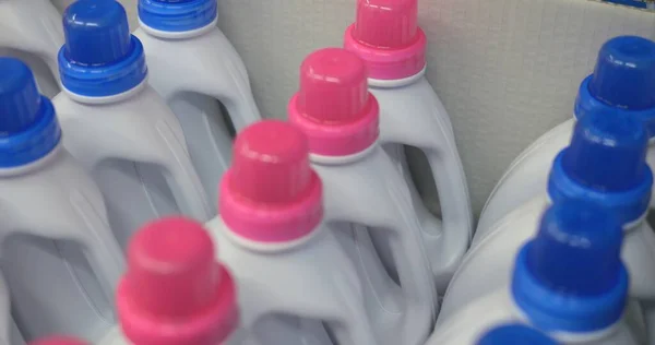 Saflar halinde işaretlenmemiş beyaz konteynır şişeleri. Evdeki kimyasallar pembe ve mavi kaplamalar. Sıvı için tutacağı olan birden fazla şişe karton kutuda duruyor. Yüksek kalite fotoğraf