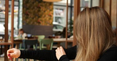 Genç bir kadın iç mekânlarda toz toplar ve çıkartır. Elbise kolundan pamuk ve iplik çıkartır. Halka açık bir yerde uzun kahverengi saçlı, bulanık arkaplan sahibi bir kadının yan görüntüsü. Yüksek kalite 4k görüntü