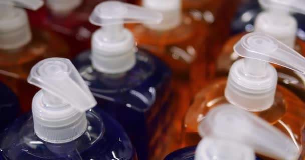 无牌透明彩色瓶的消费者化妆品与水泵 没有标签的深蓝色和橙色洗发水或液体肥皂在消费者包装上没有标志 高质量的4K镜头 — 图库视频影像