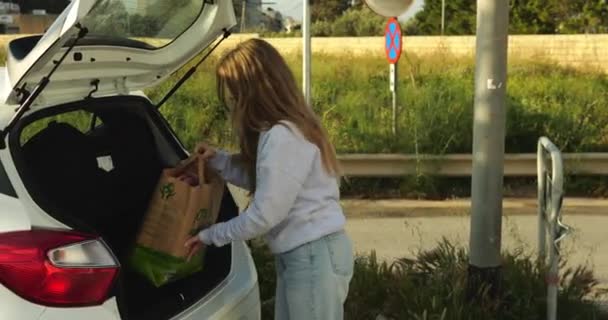 여자는 자동차 트렁크에서 구매와 친환경 재활용 가방을로드합니다 환경에 인식을 성인은 — 비디오