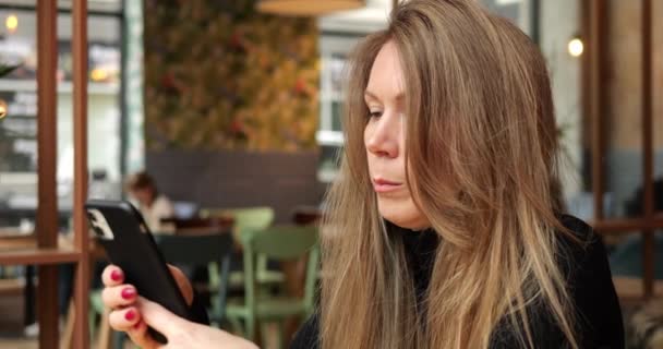 Сконцентрированная Сосредоточенная Молодая Женщина Сидит Кафе Смотрит Экран Смартфона Момент — стоковое видео