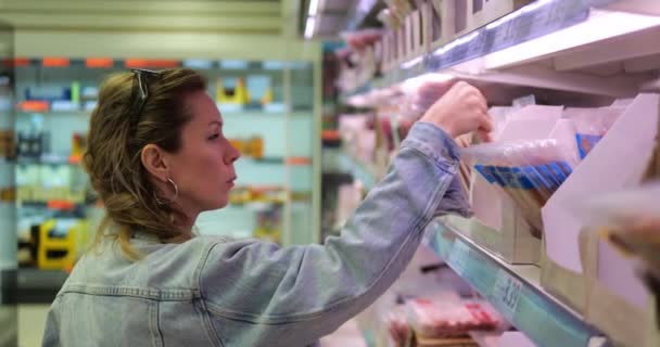 Giovane Donna Scaffali Del Supermercato Sceglie Confezione Prodotti Base Carne — Video Stock