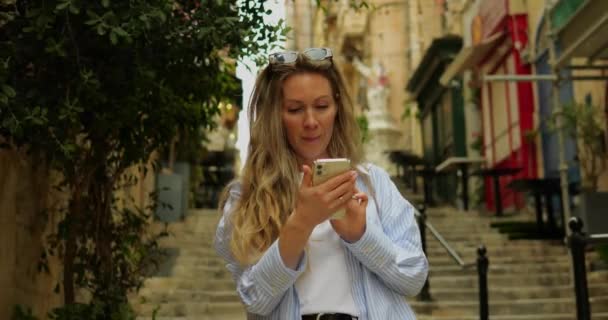 Młoda Kobieta Okularach Przeciwsłonecznych Centrum Starego Miasta Przesuń Smartfon Cieszyć — Wideo stockowe