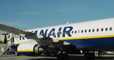 WARsaw, POLAND - 23 Nisan 2023 Ryanair modern yolcu uçağı güneşli bir günde havaalanında duruyor. Büyük jet havaalanına gelecek insanları bekliyor. Ölümcül. Uçakla seyahat etmek.