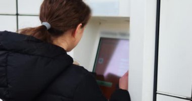 Esmer kadın interaktif paket terminali verilerini dolduruyor. Genç bayan uygun depolama ünitesinin kilidini açmak için paket boyutlarını yazar