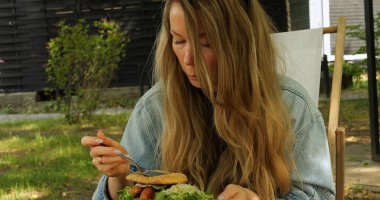 İnce genç bir kadın yüksek kalorili çöreklerden kaçınmak için çatal kullanır. Kadın beslenme uzmanının tavsiyeleriyle günlük kalori limitini aşmıyor