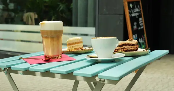 Ahşap masada rafine şekersiz bir tabak sağlıklı kekin yanında Latte ve kapuçino. Sağlıklı beslenmeye bağlı insanlar için ideal bir seçim.
