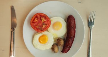 Cafe masasında sıcak ve tatlı yemekli lezzetli kahvaltı servisi var. Kızarmış yumurta ana yemeği hazırlarken, krep ve bir fincan kahve tatlı olarak servis ediliyor.