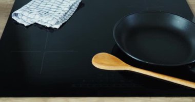 Dilimlenmiş domatesler ve şampiyonlar mutfaktaki sobanın yanında tahta kesiyorlar. Çay havlusu ve kaşıkla organik malzemeler yemek yapma aşamasını sembolize eder.