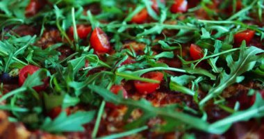 Pizza, müşteri açlığını gidermek için vişneli domates ve roka yeşili içerir. Tabak, eşsiz bir tat ve hassas dolgu nedeniyle dikkat çeker.