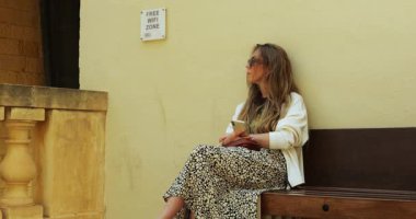 Bayan, özel ücretsiz Wi-Fi bölgesinde akıllı telefonuyla oturarak saç ayarlıyor. Olgun kadın treni bekler ve aletle internete bağlanmaya çalışır.