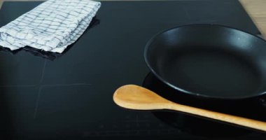 Yemek yapmadan önce taze malzemelerin ve özel ekipmanların hazırlanması. Pişirme işlemi sırasında yemekleri karıştırmak için tava ve kaşık indüksiyon hob yalan