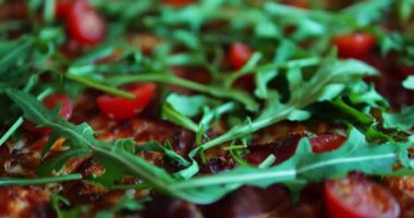 Hamur tabağı pizzacıda müşterilerin dikkatini çekerek masanın üzerinde yatıyor. Kiraz domatesli ve roka yeşili özel pizza hızlı atıştırma olanağı sağlar.