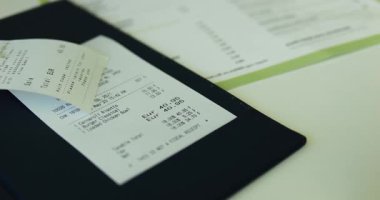 Sipariş edilen yemeklerin listesini içeren restoran faturası salondaki masanın üzerine özel para kutusuna konmuş. Çek, müşterilere bulaşık fiyatlarını görme ve hizmet için ödeme yapma olanağı sağlıyor