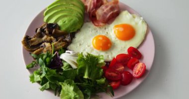 Çırpılmış yumurta ve domates, bağışıklığın güçlenmesine yardımcı olur. Dikkatlice sıralanmış organik ürünler tabakta yatıyor ve besin maddeleri içeriyor.