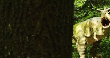 Ağzı açık ve ağaç gövdesinin arkasından boynuz manzaralı altın dinozor kopyası. Parkta sergilenen canlı benzeri model tarih öncesi vahşi yaşam hissini taşıyor.