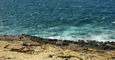 Okyanus dalgaları sahilde yuvarlanır ve kayalık sahile vurur ve doğal manzarayı aydınlatan sıçramalar yaratır. Sert denizleri ve yıpranmış kayaları olan terk edilmiş bir yer.