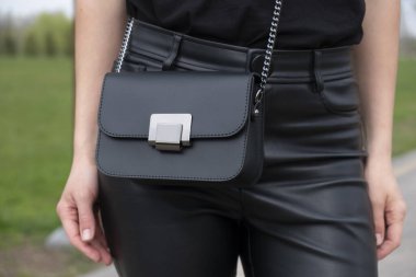 Bir model üzerinde kadın siyah deri çantası.