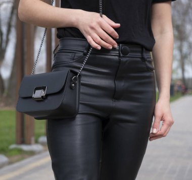 Bir model üzerinde kadın siyah deri çantası.