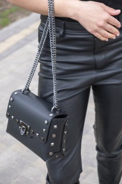  Bir model üzerinde kadın siyah deri çantası.
