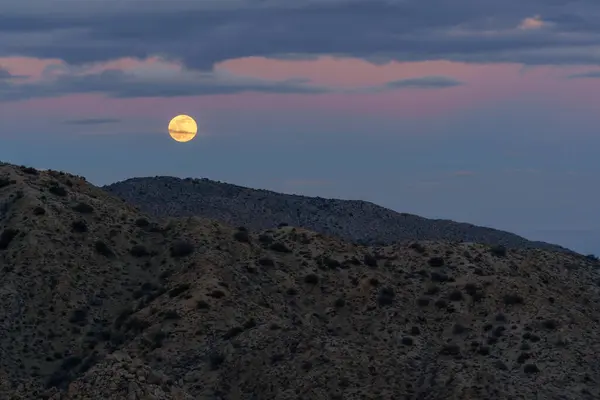 Полная Волчья Луна Облачным Пастельным Небом Над Пустынными Горными Вершинами — стоковое фото