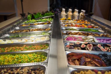 Çok çeşitli meyve, sebze ve sos çeşitleri olan yemek ve salata barı.