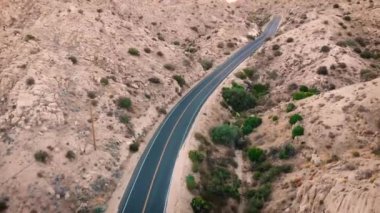 Pioneertown, California 'ya doğru giden arabasız Paved Çölü yolu. Hava aracı görüntüleri, kuş bakışı bir bakış açısıyla yol boyunca ilerliyor..