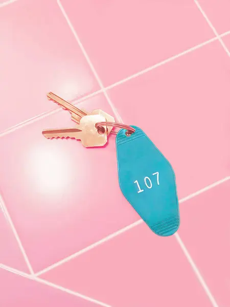Motel room key and tag on pink tile