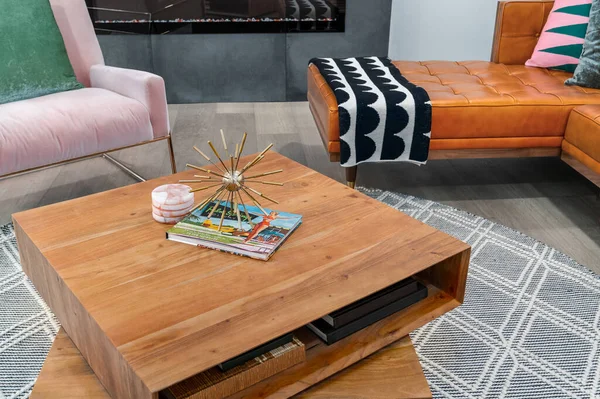 Mid-century modern wooden coffee table with books in a modern living room.