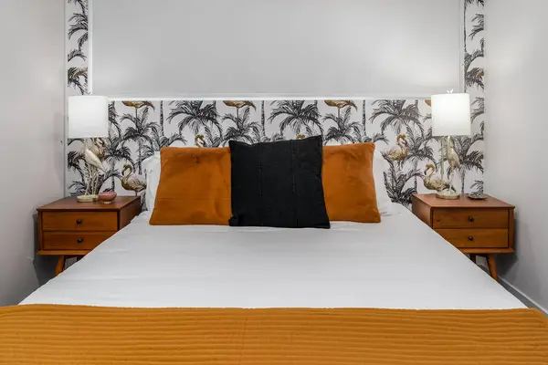 Brown and white bedroom interior with a palm tree and flamingo theme