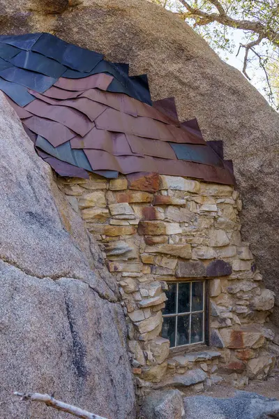 Old window, stone wall, and metal roof shingles at Eagle Cliff Mine cabin at Joshua Tree National Park, California