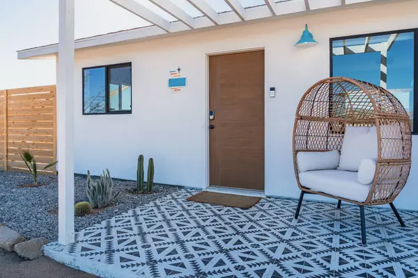 Gündüz vakti fayanslı ve rattan sandalyeli modern bohem çöl ev verandası.