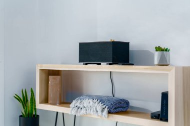 Saç tokası bacaklı ahşap masa radyo ve modern bir bohem çöl evinde katlanmış battaniye.