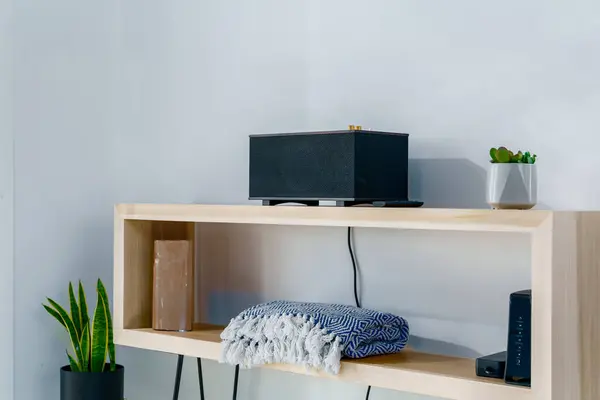 Saç tokası bacaklı ahşap masa radyo ve modern bir bohem çöl evinde katlanmış battaniye.